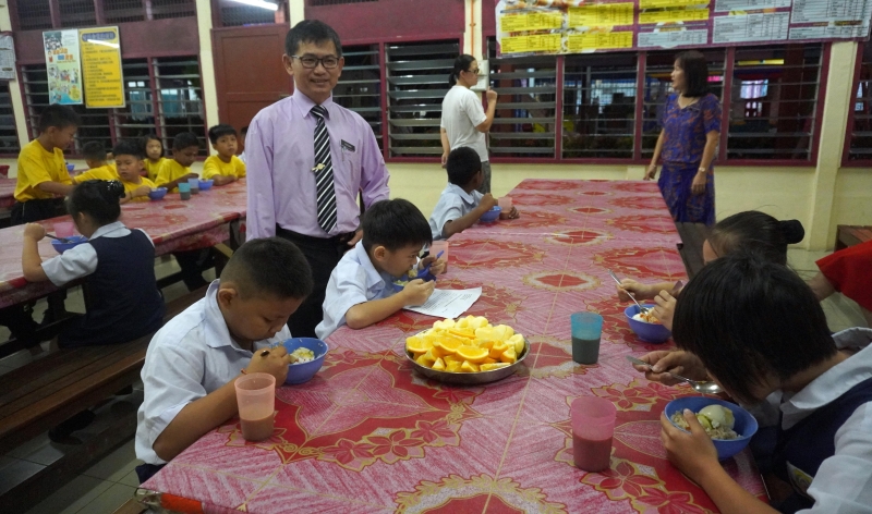 謝福玖（站者）陪學生在食堂吃早餐，以確保不空腹上課。