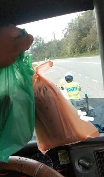 交警帮罗里司机打包饭和冷饮，让司机大为感动。（取自Penang Kini脸书）