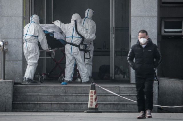 Medical staff carrying a patient into Jinyintan hospital where patients infected by a SARS-like virus are being treated. AFP