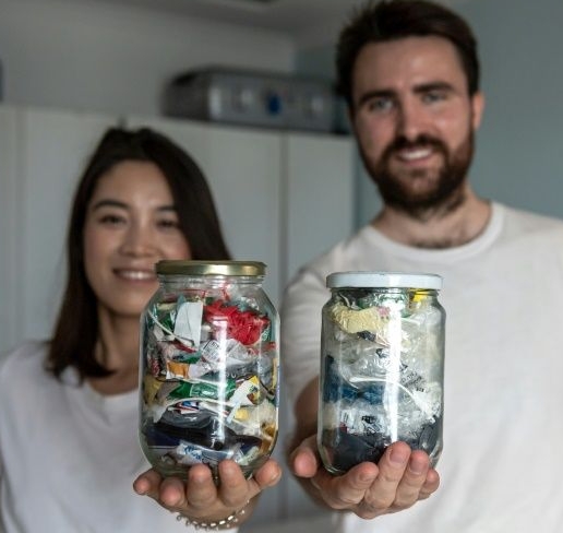 Carrie Yu and Joe Harvey, founders of zero-waste shop The Bulk House, pose with jars containing all of their personal waste collected over three months at their home in Beijing. AFP