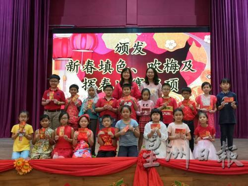培一董事刘蕙芳（后排右）颁发红包予三四年级新春吹梅比赛得奖同学。