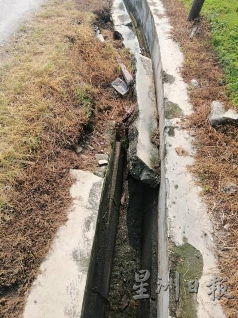 根登新村淡峇汉8路的排水沟崩裂，在下大雨时引起沟水倒淹至马路。