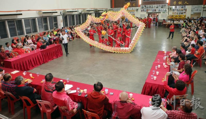 怡保精武龙狮团舞动祥龙庆春节，吸引许多出席者拿起手机拍下这精彩的表演。