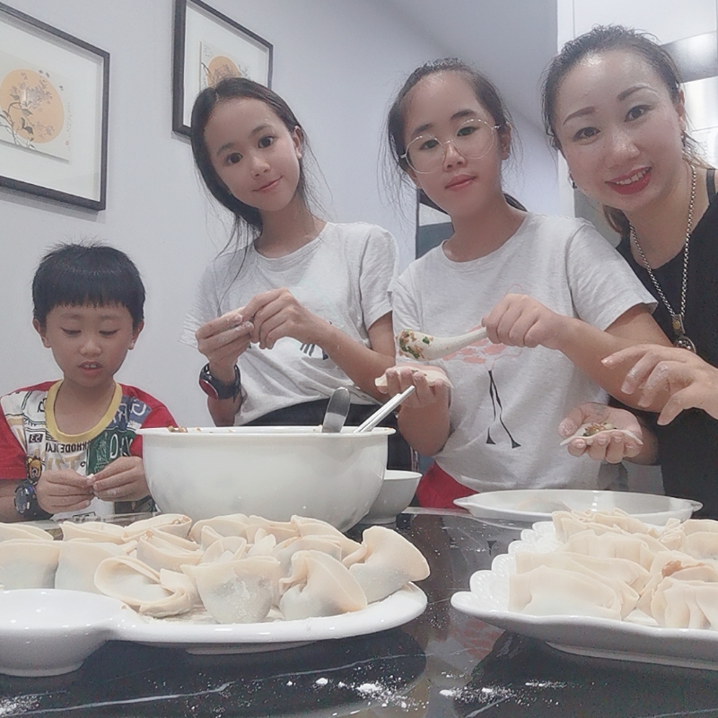 郑元萍（右一）与孩子们一同包饺子迎新年。