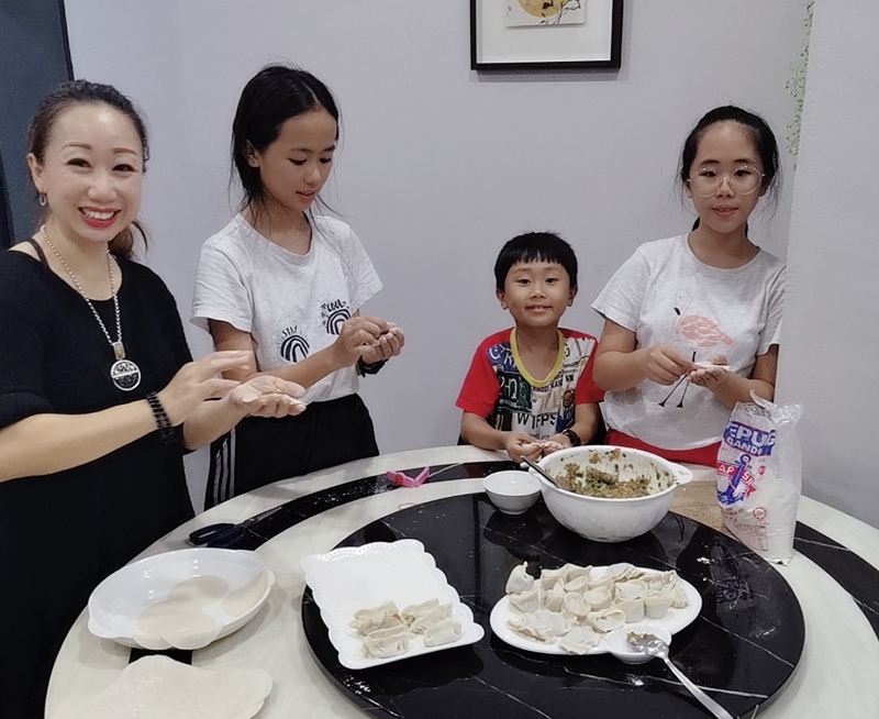 13年过去，郑元萍（左一）的儿女也渐渐长大，将她的包饺子手艺学习起来。