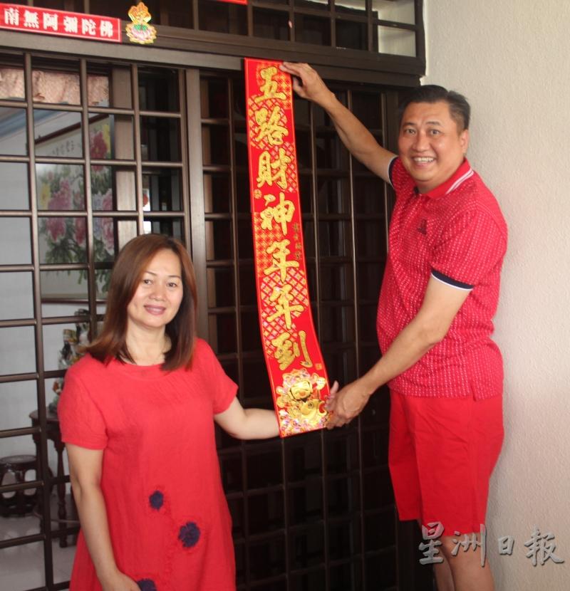 杨菽娟（左）与丈夫郭廷平，一起在家中贴春联迎春节。