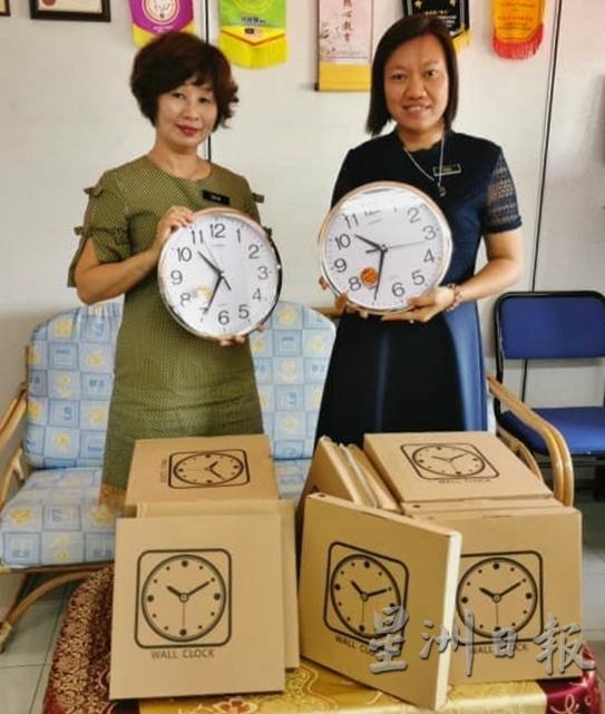 瑞昌钟表店赞助20个壁锺给育英华小，左为校长陈美兰。