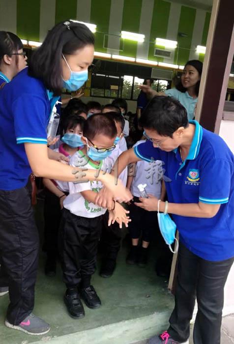 校方为了确保学生学会洗手消毒，老师手把手地教学生。右一为莫美凤。