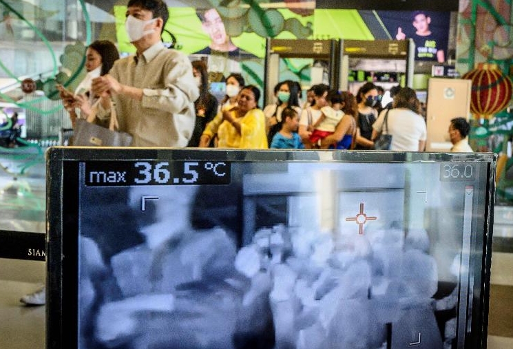 People wearing face masks pass in front of a thermal scanner as they enter a shopping mall in Bangkok. AFP People wearing face masks pass in front of a thermal scanner as they enter a shopping mall in Bangkok. AFP