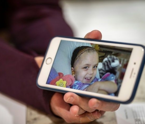 Cathy smiles tenderly as she scrolls through photos of Olivia on hospital beds. AFP Cathy smiles tenderly as she scrolls through photos of Olivia on hospital beds. AFP
