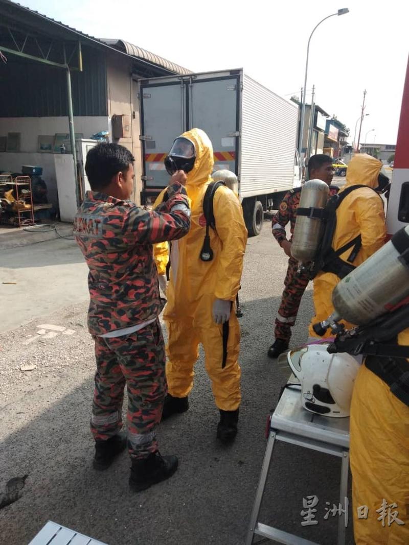 消拯人员协助彼此穿上保护装，以确保安全进入受感染的地区清理氨气。