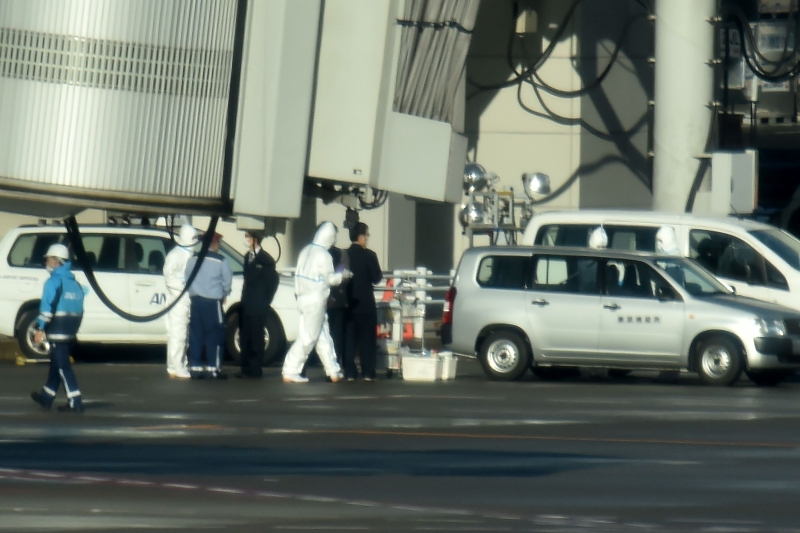 载有206名日本公民及日本医疗团队的包机周三上午8时多飞抵东京羽田机场，停机坪上身防护衣的医疗人员守候。 （法新社照片）