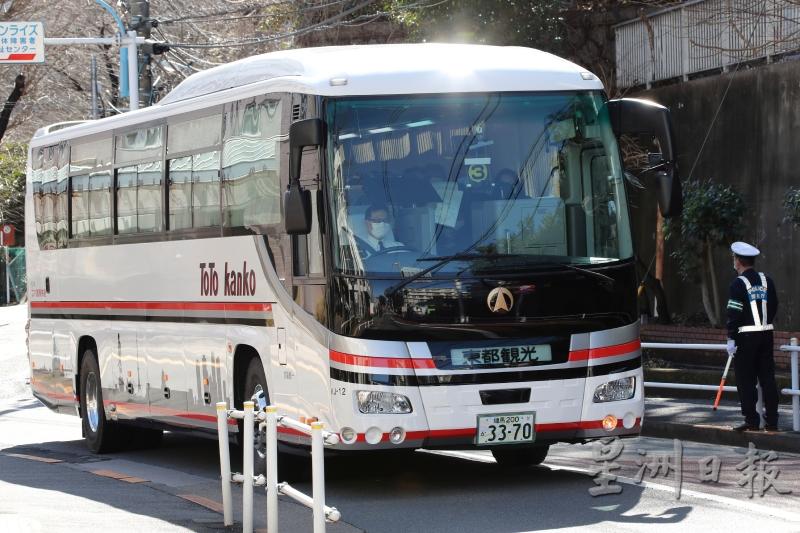 首批滞留武汉的日本人抵达东京后，乘搭巴士离开羽田国际机场。（美联社照片）