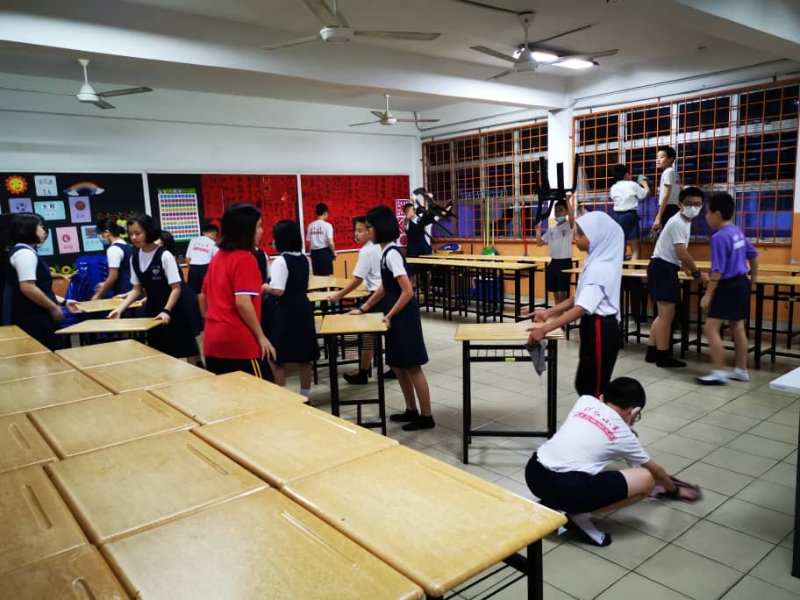 巴生兴华小学在开学日一早，总动员学生为各班级进行消毒，就连地板亦不放过。