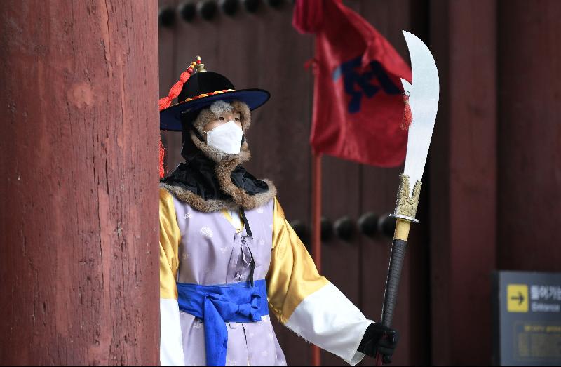 A 'palace guard' member in traditional Korean costume wears a face mask while performing for tourists at Deoksugung Palace in Seoul amidst concerns about the spread of a new coronavirus. AFP