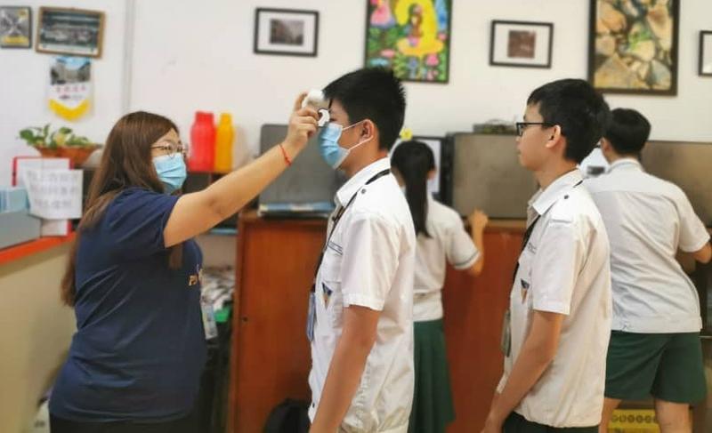 老师为培风宿舍生测量体温，监督他们的健康情况。