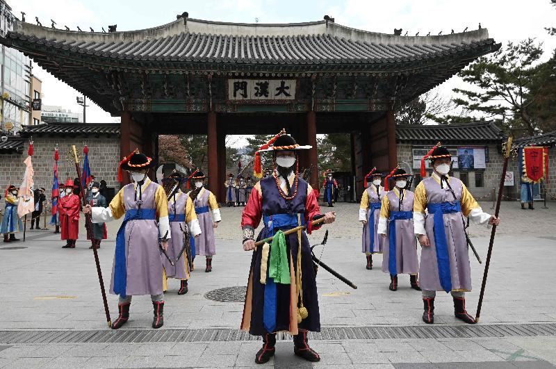 'Palace guard' members in traditional Korean costume wear face masks while performing for tourists at Deoksugung Palace in Seoul amidst concerns about the spread of a new coronavirus. AFP