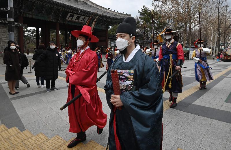 'Palace guard' members in traditional Korean costume wear face masks while performing for tourists at Deoksugung Palace in Seoul amidst concerns about the spread of a new coronavirus. AFP