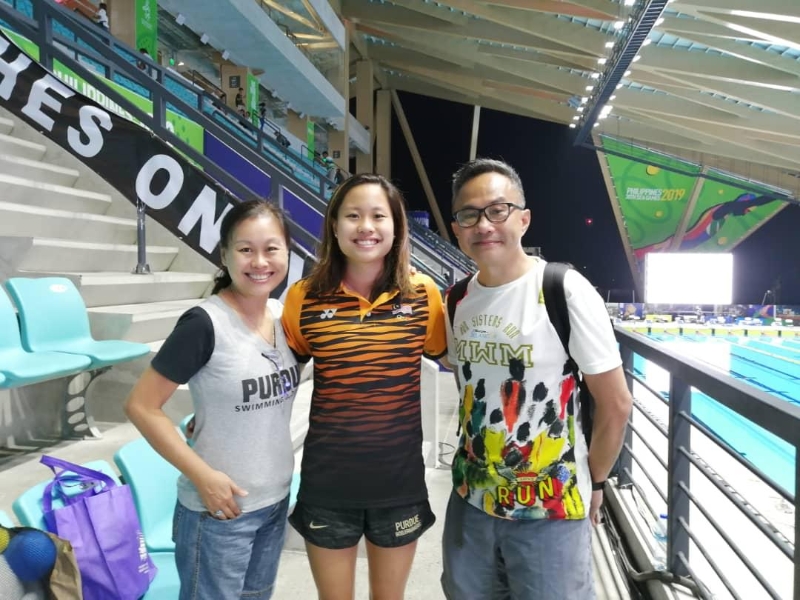 彭靖恩（中）坚持游泳运动选手生涯的背后，家人的支持鼓励为其一大支柱。图为菲律宾东运期间彭靖恩与亲赴现场观赛为其“撑场”的父母合照。