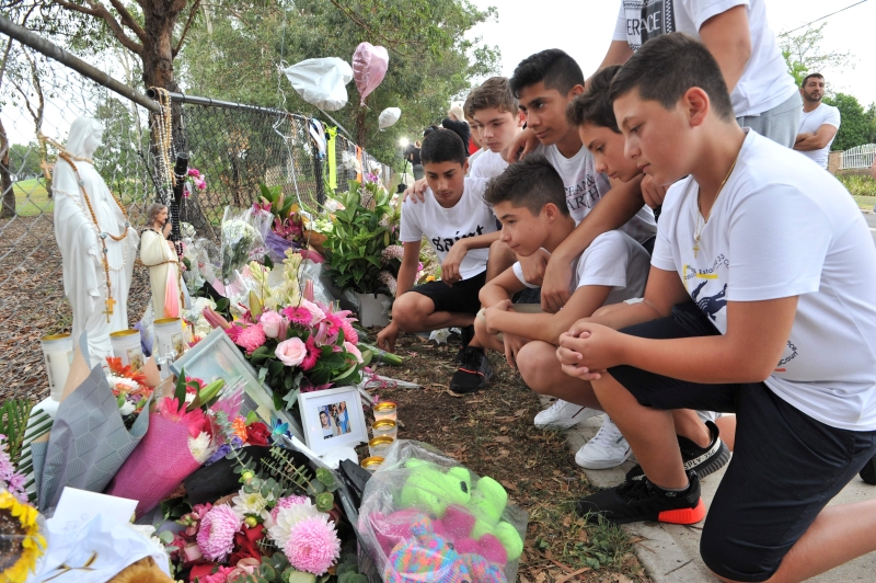 死者同学在案发现场附近的临时悼念会向死者献花。（法新社照片）