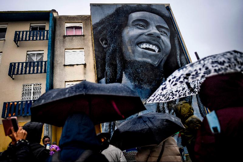 Visitors watch a mural by Portuguese artist Odeith depicting Jamaican singer Bob Marley during a guided visit to the Quinta do Mocho neighborhood of Sacavem outside the Portuguese capital of Lisbon. AFP