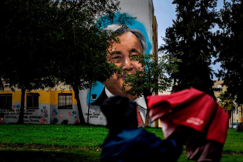 Visitors watch a mural depicting UN Secretary-General Antonio Guterres by Portuguese artist Sergio Odeith during a guided visit to the Quinta do Mocho neighborhood of Sacavem outside the Portuguese capital of Lisbon. AFP