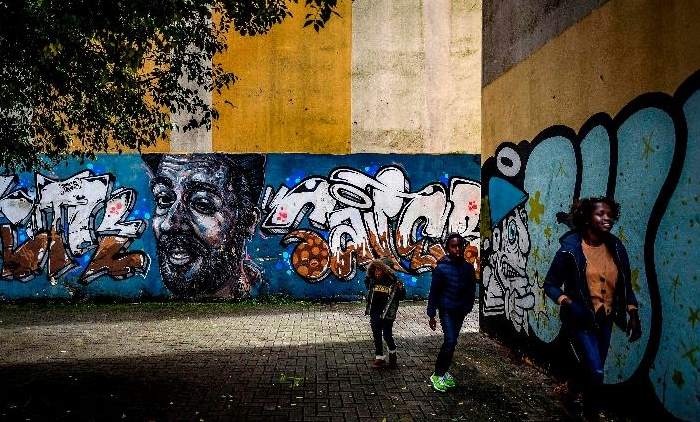 Children walk past a mural in Quinta do Mocho neighborhood of Sacavem outside the Portuguese capital of Lisbon. AFP