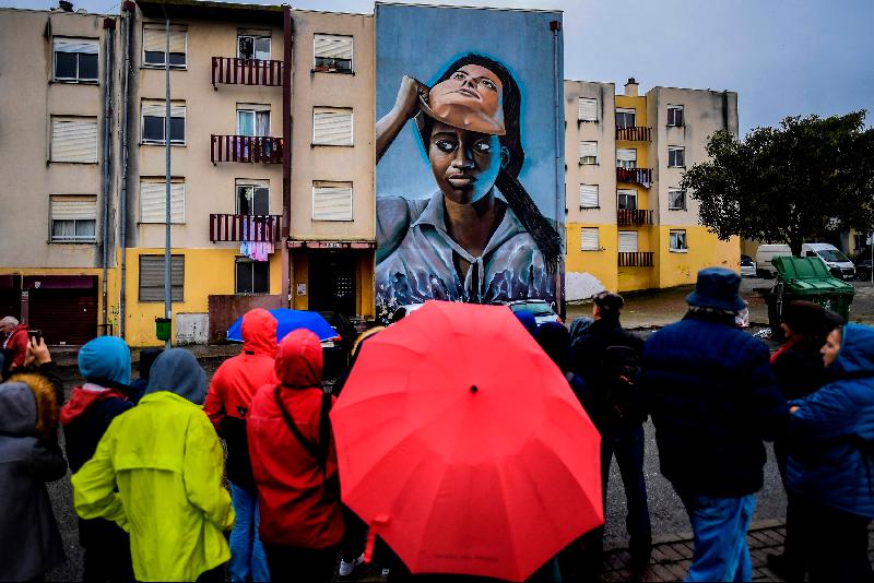 Visitors watch a mural by Portuguese artist Nomen during a guided visit the Quinta do Mocho neighborhood of Sacavem outside the Portuguese capital of Lisbon. AFP