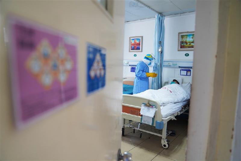 新华社刊出中国工程院院士锺南山表示，目前全国的疫情仍处於上升期，可能在未来10天至两周左右出现高峰。图为中国隔离区的医生在病房和患者沟通病情。（中新社提供）