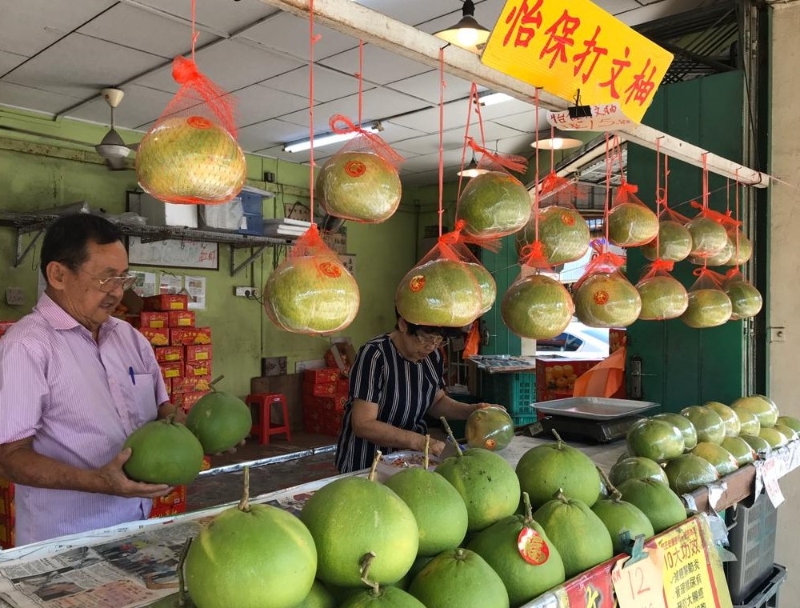 商家將柚子擺放在售貨架上。