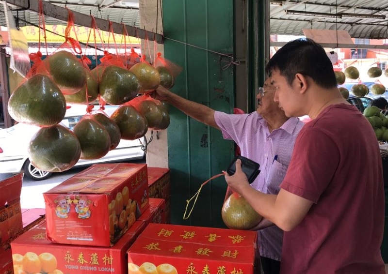 顧客前往水果店選購柚子。