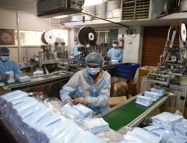 A worker packs protective face masks at a production facility outside Ahmedabad, India. AFP