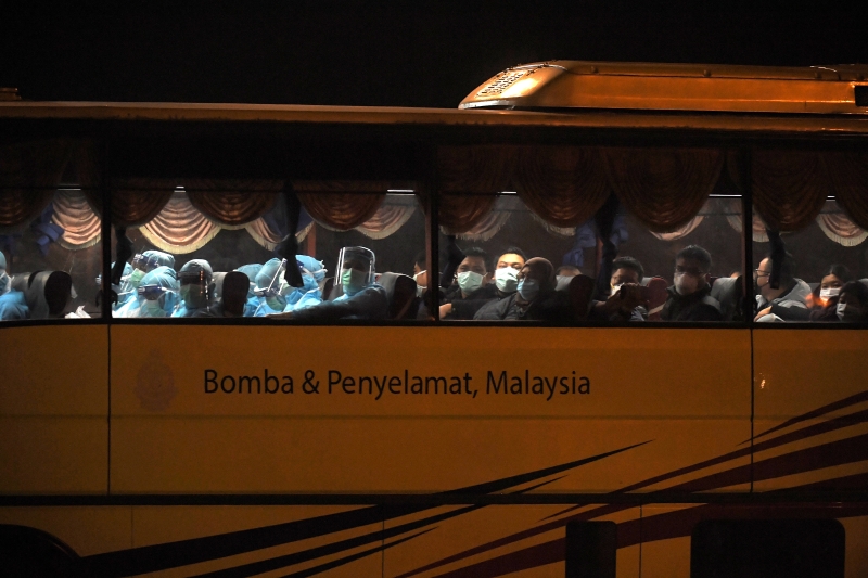医务人员和返国公民坐在同一辆巴士，共同抗疫。
