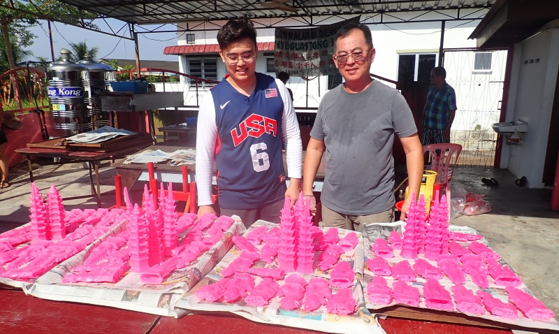 陈国霖（右）的糖塔制作手艺承传自祖父及父亲，现在则传给儿子陈礼峻。