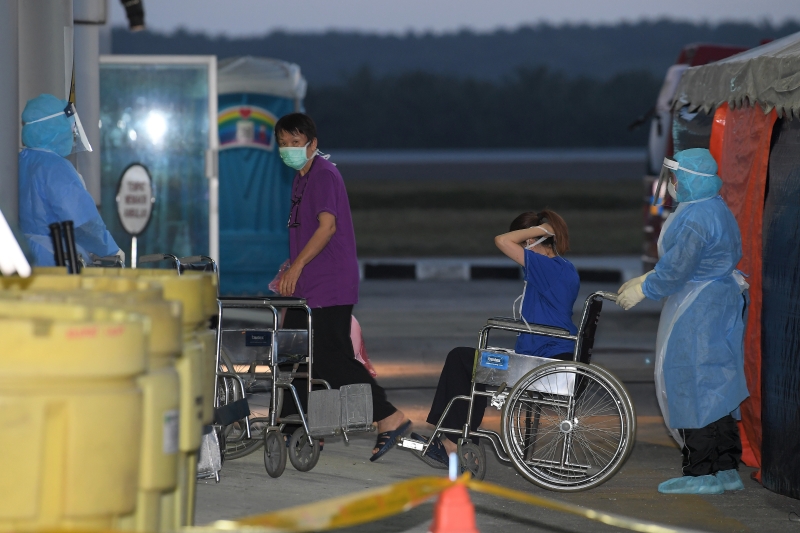 行动不便的返国公民，由医务人员协助推出机场。