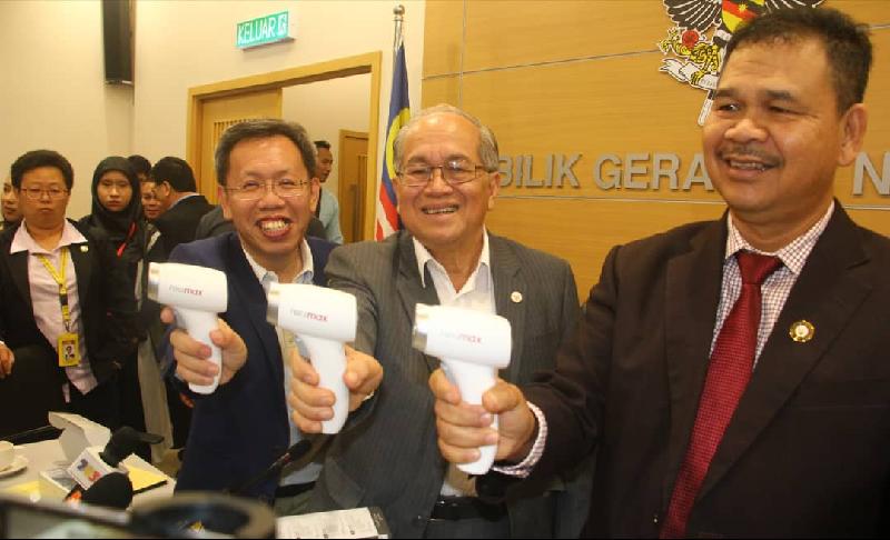 
右起伊巴宏、道格拉斯及沈桂贤向记者展示体温测量器（Thermo Gun），以在边界关卡检查出入境者的体温。