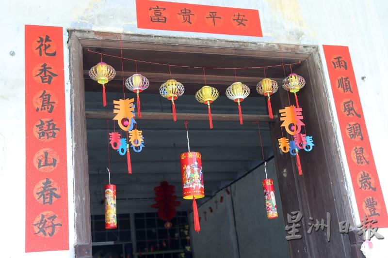 谢彭进在住家的入口处悬挂各式各样的新年装饰，迎接华人农历新年。