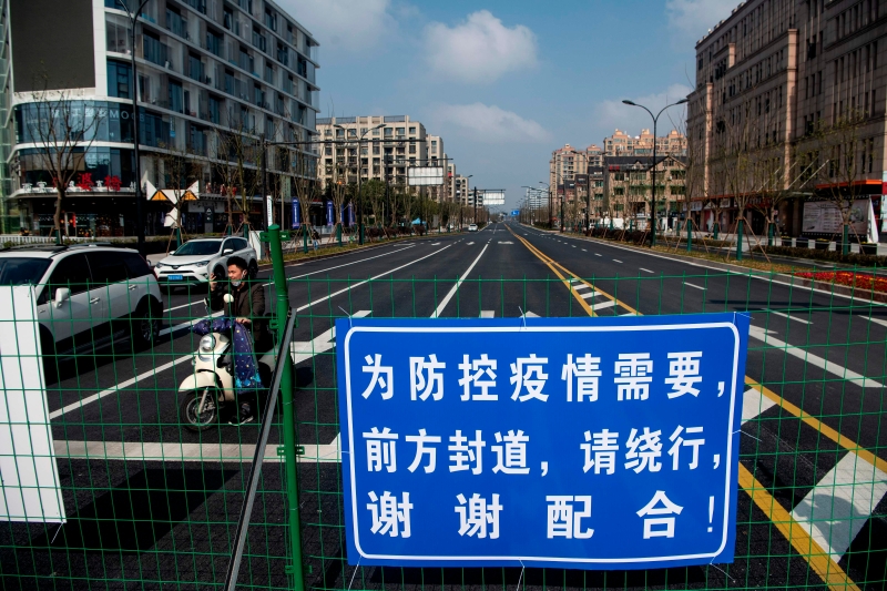 距离上海西南方约175公里、靠近中国电商巨头阿里巴巴总部杭州附近的一条街道上，列着为防控疫情的封道告示。（图:法新社）