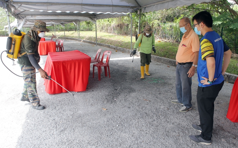 罗健伟（右起）和昆仑喇叭村长丁春荣视察工作人员在用餐区的消毒情况，确保做足防疫与防蚊的双重保险措施。