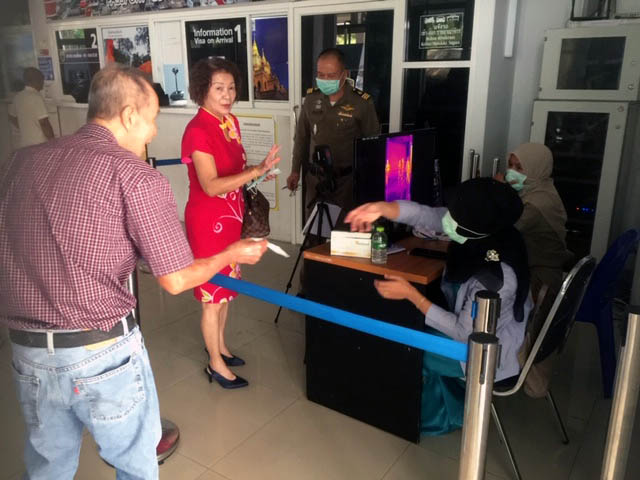 泰国移民局在勿洞关卡装置体温自动扫描器，及分派口罩给入境者。