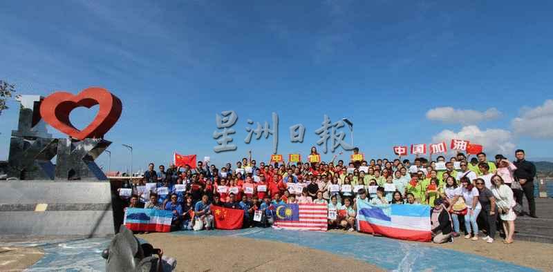 本地旅游业者聚集在亚庇海滨走廊“I Love KK”标志打卡景点，高举“中国加油”大字报，中国国旗、大马国旗和沙巴州旗，为自己和为中国打气。