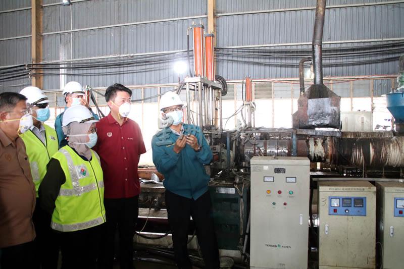 执法员（右起）向黄思敏、依斯纳莱沙与陈国耀讲解工厂如何运作。