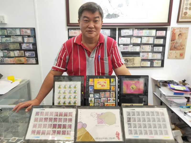 吴金淼洋洋得意地展示，所收藏的鼠年系列邮票。