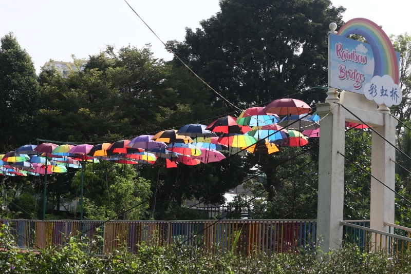  彩虹桥上挂有五颜六色的雨伞，非常亮眼。