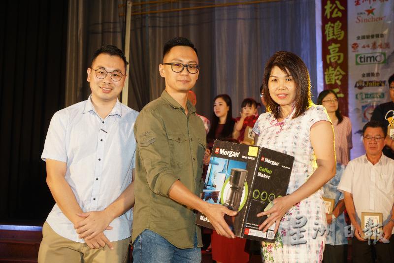 三星电子经理陈家辉（左起）、福隆企业有限公司经理谭伟忠颁发幸运抽奖奖品给幸运儿。