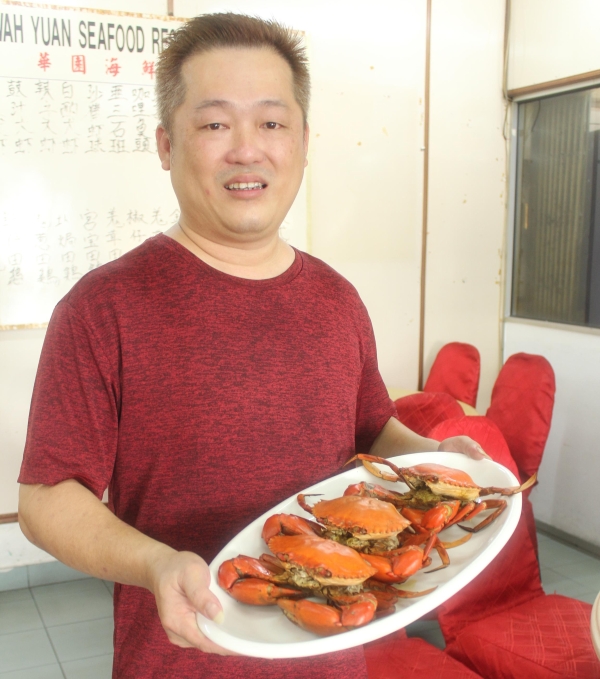 班达马兰华园海鲜酒楼店主李进星表示，店内售卖的焗蟹，是使用粗盐进行腌制，以留住螃蟹本身的鲜味。（图：星洲日报）
