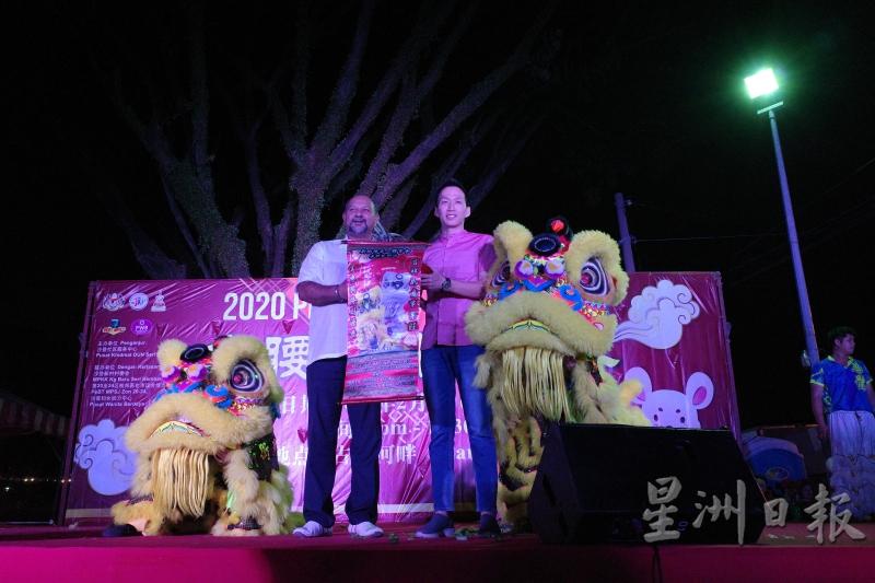 哥宾星（左起）及欧阳捍华接获瑞狮赠送的福品后，为2020庚子鼠年“古腰河畔迎新春”元宵活动揭开序幕。