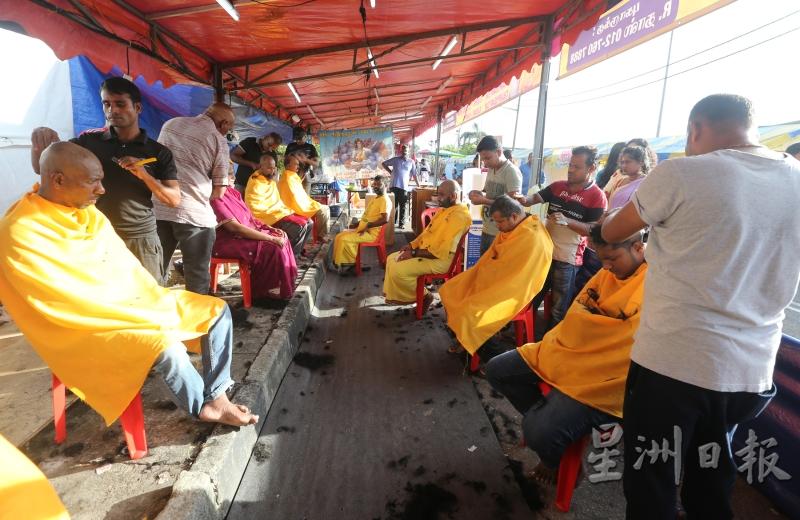 信徒在帐篷内排排坐，由理发师剃头并抹上一层橙黄色粉末。（图：星洲日报）