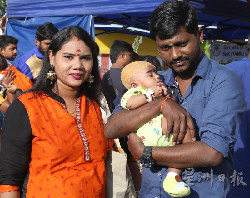 帝亚古（右）与妻子薇玛拉带着3个月大的儿子参加大宝森节庆典，也让儿子剃头祈求身体健康。（图：星洲日报）