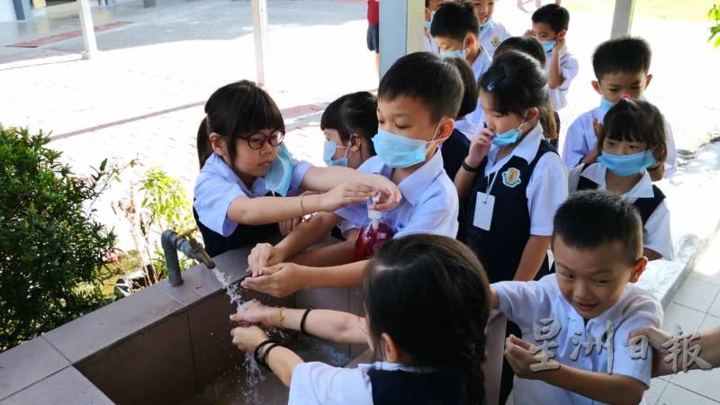 布先喜州华小学生排好队伍，一个接一个洗手，保持个人卫生。